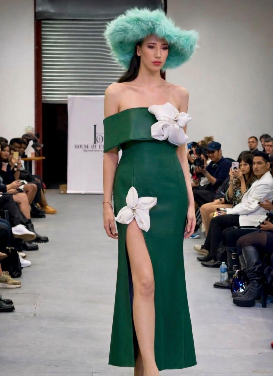 Emerald off-shoulder gown with a hand-set floral brooch, runway