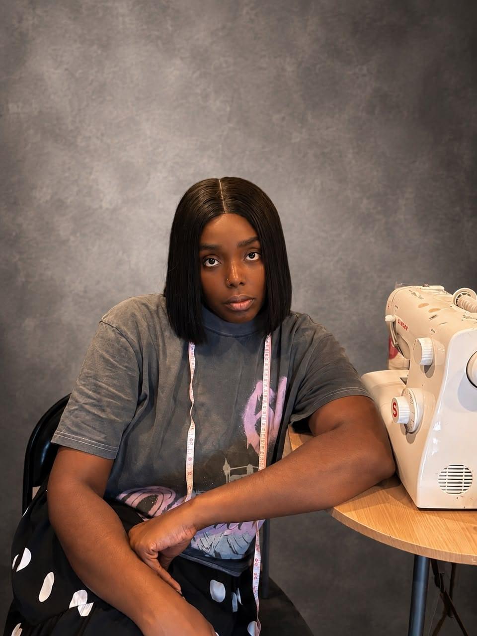 Adora Vanessa Mofunanya at her sewing table with a Singer sewing machine
