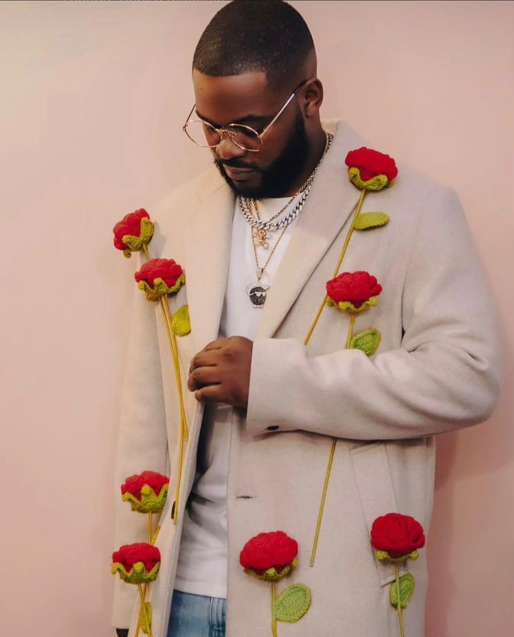 Detail view of the hand-crocheted rose appliqué on the custom overcoat